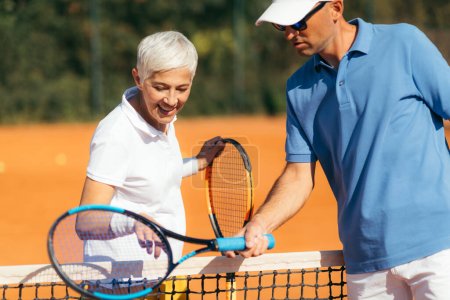 Téléchargez les photos : Cours d'activité de tennis pour personnes âgées avec instructeur - en image libre de droit