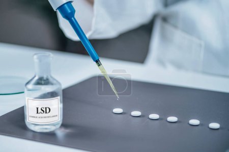 Téléchargez les photos : Médicament psychédélique Recherche en thérapie LSD, scientifique préparant de petites doses de LSD en laboratoire pour un traitement expérimental des troubles psychiatriques - en image libre de droit