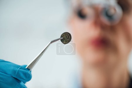 Photo for Professional coin expert examining ancient coins with magnifying glass - Royalty Free Image