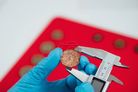 Photo for Measuring ancient coin size with caliper - Royalty Free Image