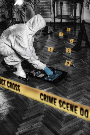 Foto de Ciencias forenses. Experto forense recogiendo pistas de una escena del crimen
. - Imagen libre de derechos