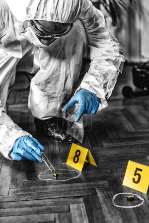 Photo for Forensic Expert collecting bullet casings from a Crime Scene - Royalty Free Image