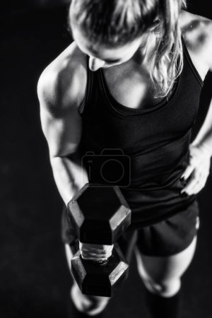 Photo for Cross training. Young woman exercising with dumbbells - Royalty Free Image