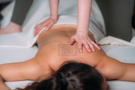 Téléchargez les photos : Massage du dos dans un salon de massage, femme ayant un massage relaxant du dos. - en image libre de droit