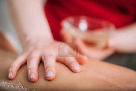 Photo for Massaging with massage oil, hands of a female massage therapist massaging a female client - Royalty Free Image