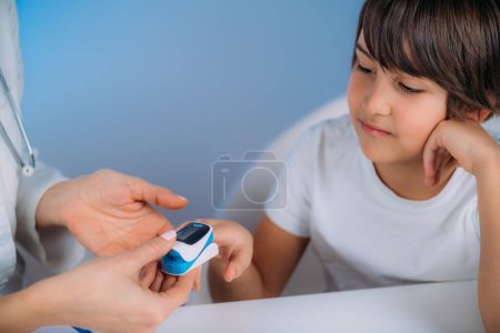 Photo for Pulmonology pediatrician measuring blood oxygen levels with pulse oximeter - Royalty Free Image