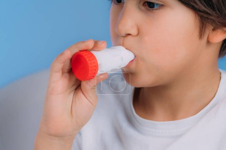 Photo for Pediatric pulmonologist helping little boy with aero inhaler. Pulmonologist, medical doctor who specializes in the diagnosis and treatment of diseases and disorders of respiratory system, lungs, bronchial tubes, trachea and structures involving in br - Royalty Free Image