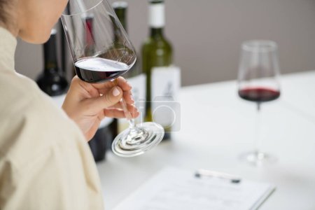 Degustación de vinos. Una mujer disfruta de una degustación de vino tinto, saboreando los sabores y aromas del vino.