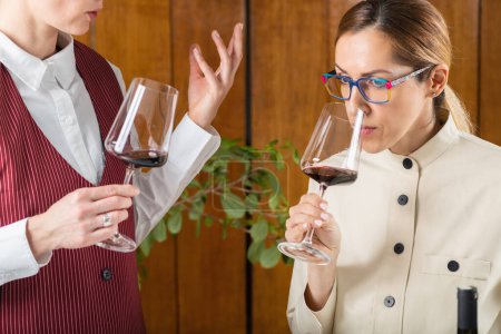 Photo for Wine Quality Assessment. Sommelier explaining student how to evaluate the quality of a wine based on its appearance - Royalty Free Image