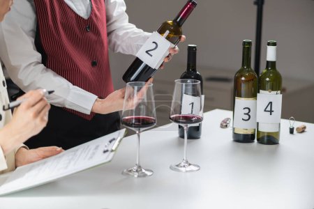 Degustación de vinos a ciegas, identificando diferentes tipos de vinos. Los participantes prueban e identifican diferentes tipos de vinos durante una cata a ciegas, aprendiendo a identificar las características de varios varietales de uva..