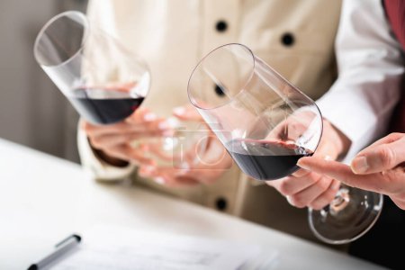 Téléchargez les photos : Dégustation de vin rouge. Les participants comparent les couleurs des différents vins rouges lors d'une dégustation de vin, apprenant à identifier l'âge du vin, le cépage et d'autres détails clés basés sur la teinte. - en image libre de droit