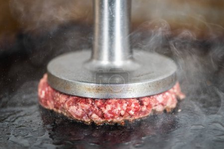 Photo for Preparing burger patties on the grill using burger smasher - Royalty Free Image
