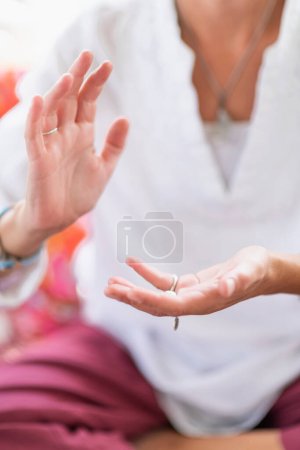 Foto de Mujer consciente sentada en posición de loto, meditando, realizando un gesto de respeto con las manos. Despertar espiritualmente. - Imagen libre de derechos