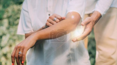 Téléchargez les photos : Cours de Reiki. thérapeute instructeur Reiki tenant la main sur le coude d'un patient - en image libre de droit