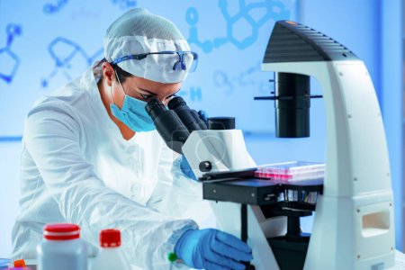 Téléchargez les photos : Ingénieur en biotechnologie inspectant la fiole de culture cellulaire - en image libre de droit