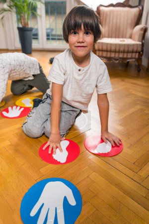 Téléchargez les photos : Groupe d'enfants jouant Twister à l'intérieur - en image libre de droit