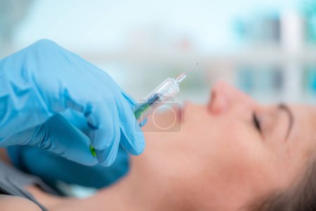 Photo for Hyaluronic acid injection treatment. Dermatology expert doing treatment to improve woman's skin's texture and hydration. Hyaluronic Acid can help plump up fine lines and wrinkles, leaving skin a more youthful. - Royalty Free Image