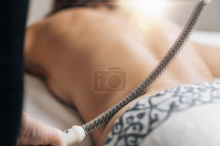 Photo for Body shaping back massage treatment with a metal rolling pin - Royalty Free Image