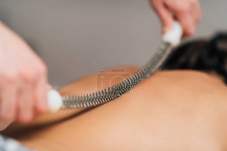 Téléchargez les photos : Massage de grattage du dos avec rouleau en métal - en image libre de droit