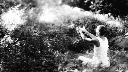 Foto de Conectando con la Naturaleza, Meditación Mindfulness. Una mujer consciente meditando, rodeada de hermosa naturaleza - Imagen libre de derechos