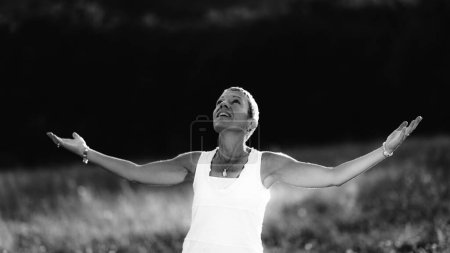 Téléchargez les photos : Lumières, une femme consciente à bras ouverts, nourrissant une énergie spirituelle positive - en image libre de droit