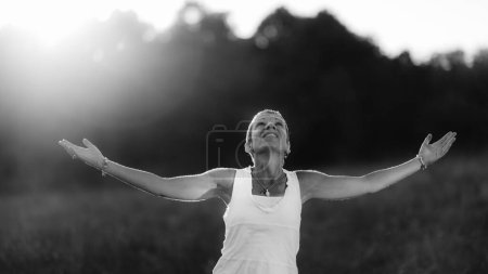 Foto de Iluminación, una mujer consciente con los brazos abiertos, que alimenta la energía espiritual positiva - Imagen libre de derechos