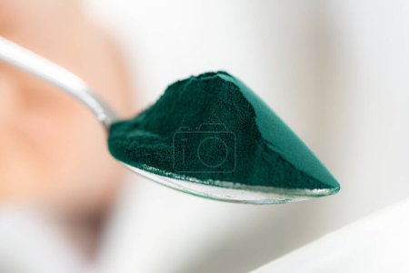 Photo for Spirulina spoonful close-up. Spoon filled with nutrient-rich superfood spirulina with its vibrant blue green color - Royalty Free Image
