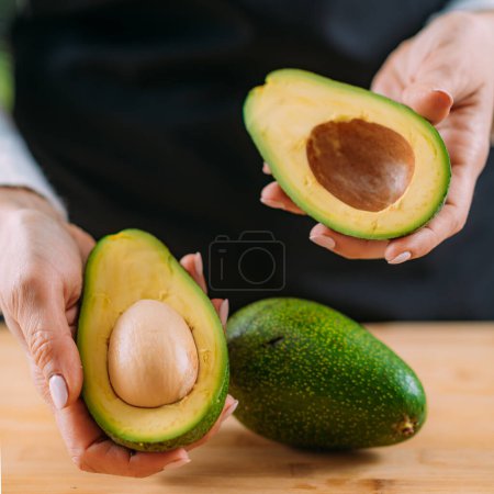 Photo for Woman holding fresh, organic avocado, superfood rich in monosaturated fat, vitamins, minerals, fibers and phytonutrients - Royalty Free Image