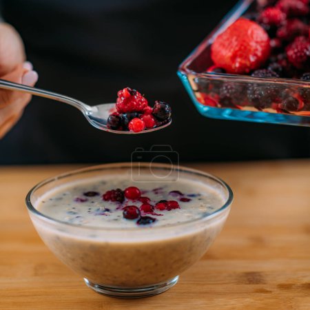 Photo for Superfoods - Making oatmeal with Oats, Soy Milk and Berries - Royalty Free Image