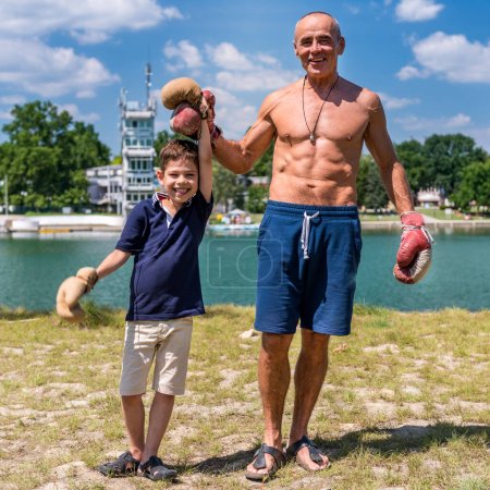 Téléchargez les photos : Grand-père athlétique joue avec son enthousiaste petit-fils de 8 ans, favorisant le plaisir et la forme physique - en image libre de droit