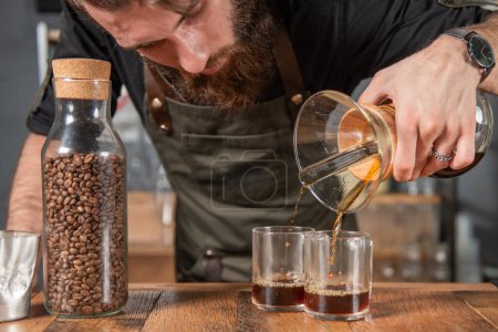 Téléchargez les photos : Barista habile préparant méticuleusement un café Chemex, démontrant l'art de verser sur le brassage - en image libre de droit
