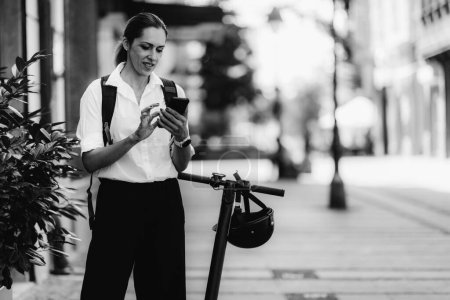 Téléchargez les photos : Portrait de femme d'affaires avec scooter électrique - en image libre de droit