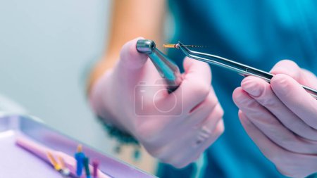 Photo for An Endodontist Holding Barbed Broach, Root Canal Treatment in Dental Clinic. - Royalty Free Image