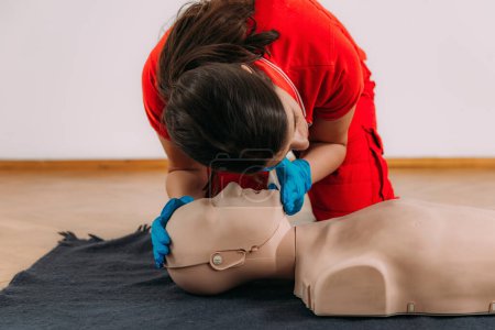 Photo for CPR with mouth to mouth technique in a first aid course using a training dummy. - Royalty Free Image
