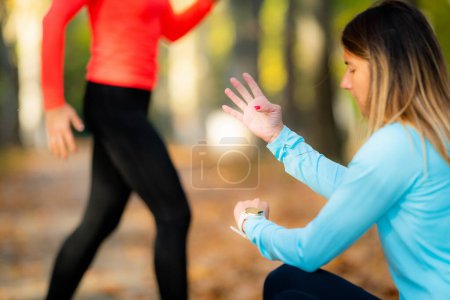 Téléchargez les photos : Woman Exercising in Public Park with Personal Trainer in the Fall. Formateur comptage sauts. - en image libre de droit