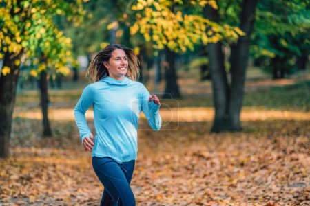 Foto de Mujer corriendo en el parque público en el otoño. - Imagen libre de derechos