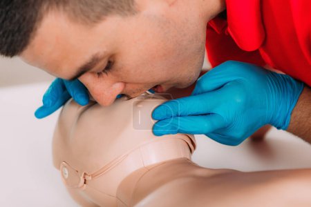 Photo for CPR with mouth to mouth technique in a first aid course using a training dummy. - Royalty Free Image