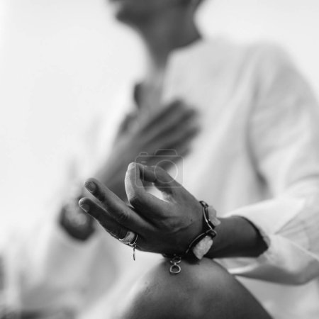Téléchargez les photos : Méditation à cœur ouvert. Femme assise en position lotus avec la main droite sur le chakra du cœur et la main gauche en position mudra. Pratique de l'autosoin pour le bien-être
. - en image libre de droit