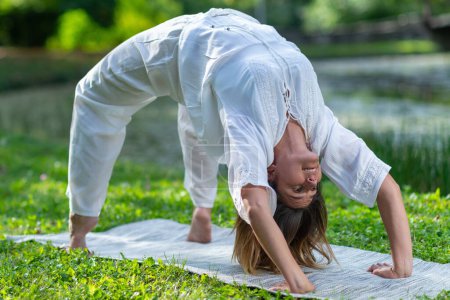 Foto de Mujer practicando con gracia yoga, rodeada de naturalezas paz y tranquilidad - Imagen libre de derechos