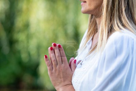 Téléchargez les photos : Les mains se rencontrent en position de prière lors d'une méditation paisible au bord de l'eau, favorisant le calme intérieur et la connexion avec la nature - en image libre de droit