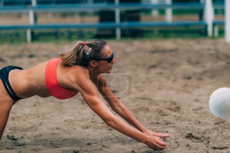 Téléchargez les photos : Les joueurs de volley-ball de plage frappent la balle - en image libre de droit
