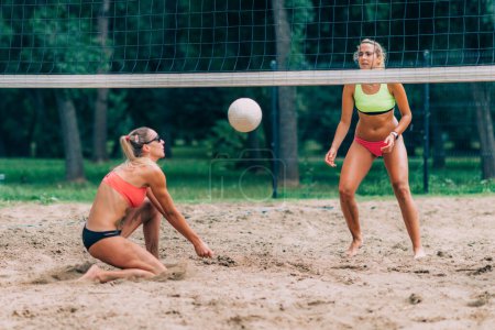 Téléchargez les photos : Les joueurs de volley-ball de plage frappent la balle - en image libre de droit