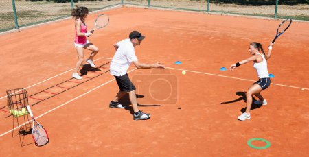 Téléchargez les photos : Groupe énergique participant à une séance d'entraînement de cardio-tennis à haute énergie, combinant fitness et tennis - en image libre de droit