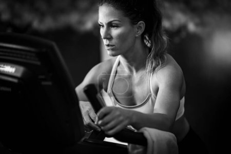 Téléchargez les photos : Athlète féminine faisant de l'exercice sur un tapis roulant, noir et blanc - en image libre de droit