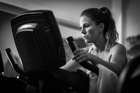 Photo for Female athlete exercising on a treadmill, black and white - Royalty Free Image