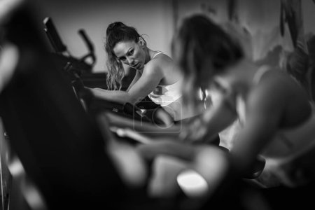 Téléchargez les photos : Athlète féminine faisant de l'exercice sur un tapis roulant, noir et blanc - en image libre de droit