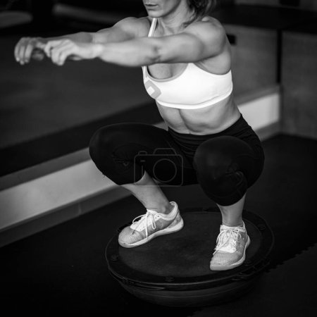 Photo for Woman doing Balance ball exercise, black and white - Royalty Free Image