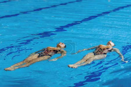 Téléchargez les photos : L "élégance d'un duo féminin de natation synchronisée lors de leur séance d'entraînement dédiée, maîtrisant des mouvements complexes avec fluidité et précision - en image libre de droit