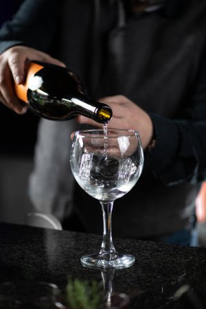 Téléchargez les photos : Le barman prépare le Cocktail Bicicletta. Verser du vin blanc dans un verre à vin. - en image libre de droit