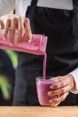 woman Creating a wholesome and nutritious shake in a blender, combining superfoods for a boost of health and flavor.